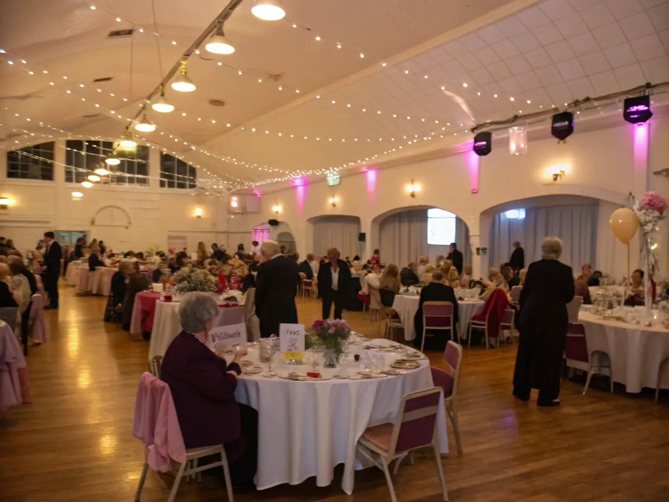 A photograph of a fundraising event, such as a gala or auction, with attendees dressed elegantly and enjoying themselves, emphasizing the importance of financial support.
